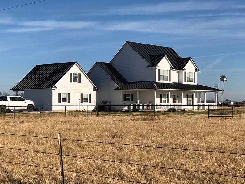 Large rural home with a black metal roof