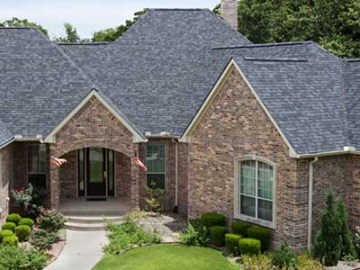 Front view of large, higher-end home with gray Malarkey shingles on its roof
